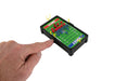 Hand holding a small electronic football game with colorful pieces on a white background