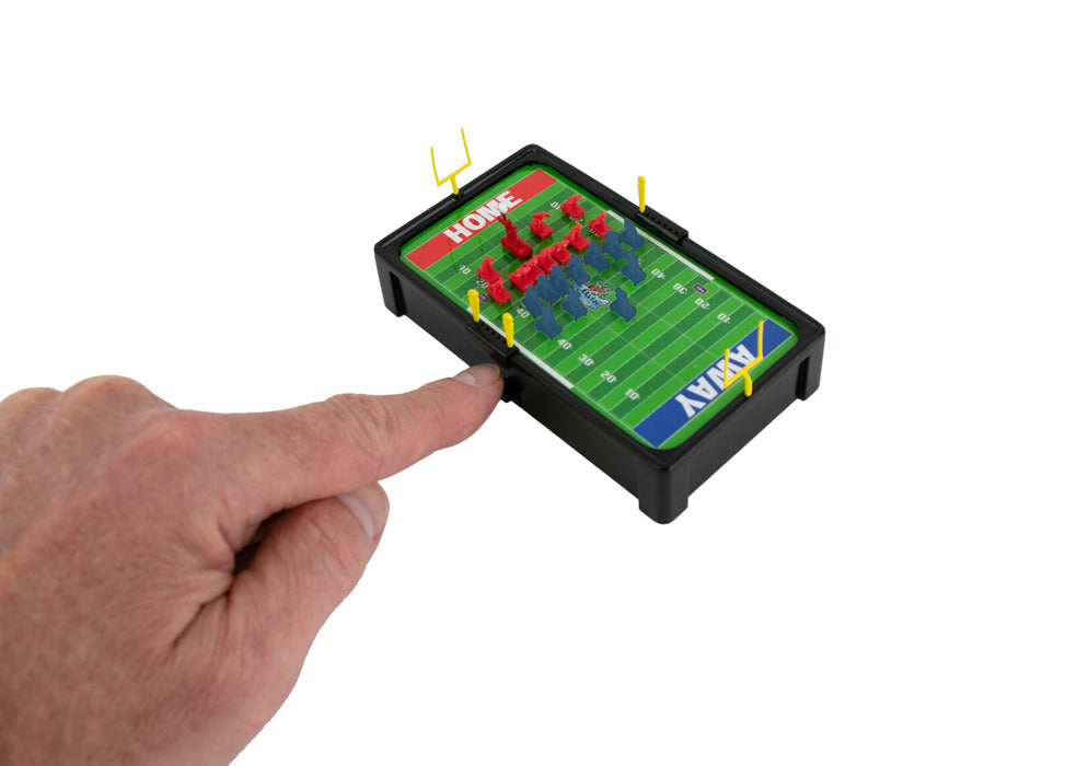 Hand holding a small electronic football game with colorful pieces on a white background