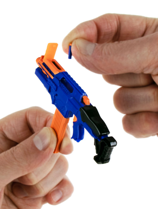 Close-up of a person assembling a blue and orange toy gun on a white background