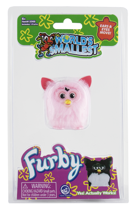 Furby in its original retail blister packaging from World's Smallest. The pink faux-fur toy has pink ears, large black eyes, and a small yellow beak, with a green and purple branded card backing.