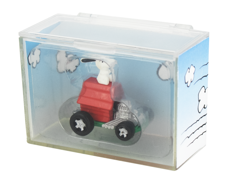 Model of a dog in a red car inside a clear display case with Snoopy illustrations on the sides.