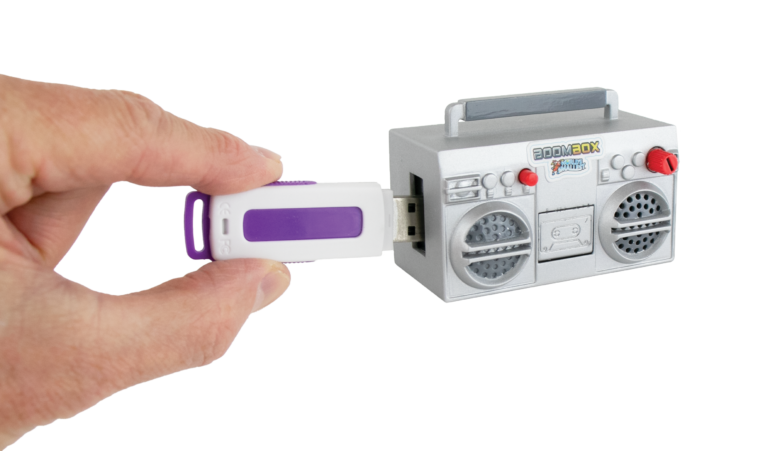 Toy boombox with USB drive attached held by a hand on a white background