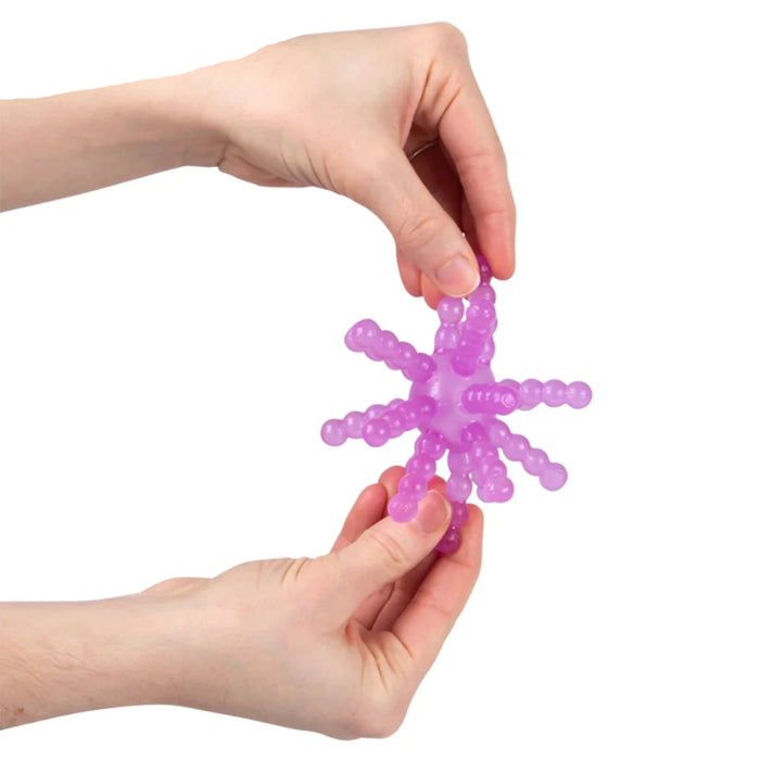 A pair of hands holding a translucent purple beaded star-shaped massage toy against a plain white background.