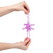 A person's hands holding a translucent purple star-shaped silicone toy with textured, beaded arms against a plain white background.
