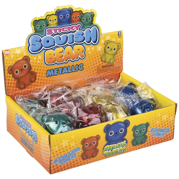 A display box of metallic sticky squish bears. The yellow and orange cardboard packaging features colorful cartoon bear illustrations and the text 'STICKY SQUISH BEAR METALLIC'.