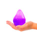 Purple glowing object held in a hand on a white background
