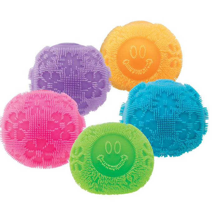 Five colorful scrubber balls with textured surfaces on a white background