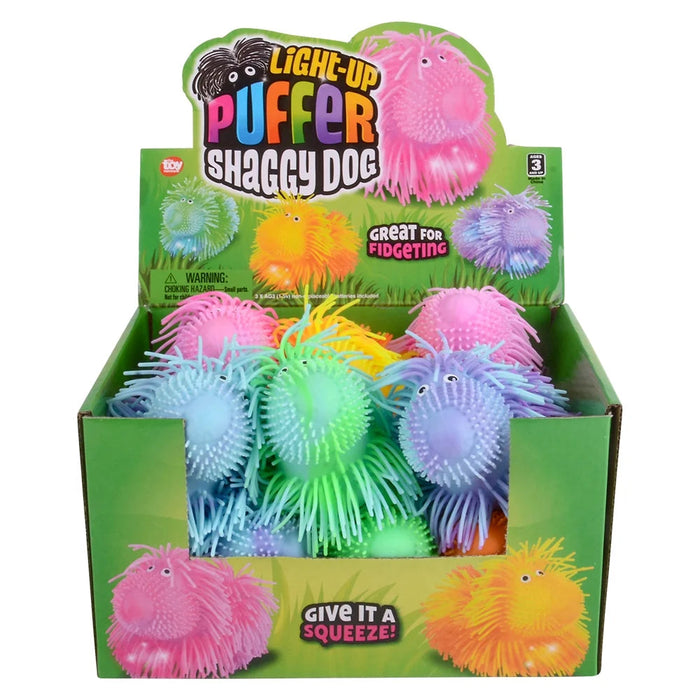 Box of light-up puffer shaggy dog toys with colorful packaging.