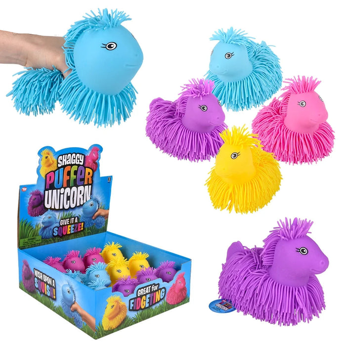 A set of colorful, fuzzy puffer unicorn toys shown on a white background, including a large blue one being held by a hand, several smaller puffer toys in purple, pink, and yellow, a retail display box, and a small brand tag. The brand 'Shaggy Puffer Unicorns' is visible on the packaging.