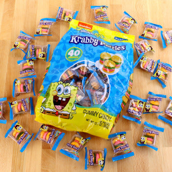 Krabby Patties gummy candy package with scattered pieces on a wooden surface