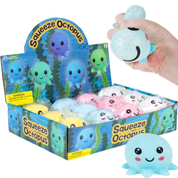 A retail display box filled with small squishy octopus toys, with a hand holding one light blue octopus above the box. The display packaging is blue with cartoon octopus graphics and the words 'Squeeze Octopus.